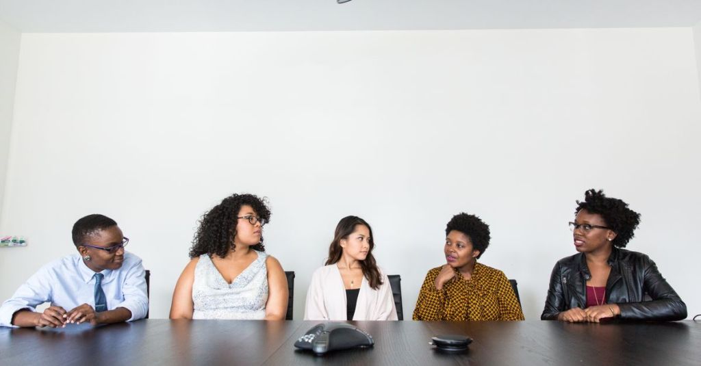 A diverse group of professionals having a meeting in a modern office setting. Teamwork and collaboration.