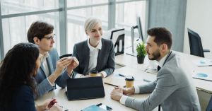 Group of professionals having a discussion in a modern office setting with natural light.