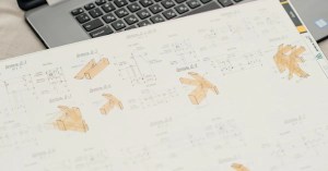 Close-up of architectural blueprints with a laptop on an office desk, showcasing design and planning.