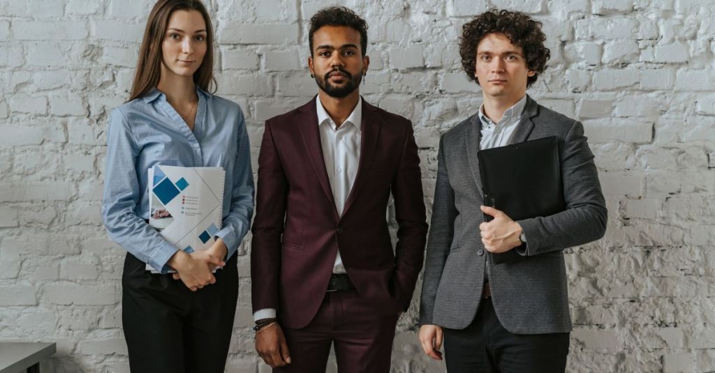 Three business professionals standing confidently in an office setting.