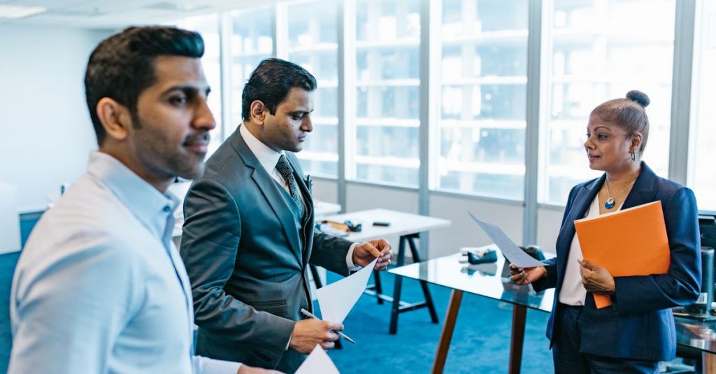 Business professionals discussing documents in a modern office environment.