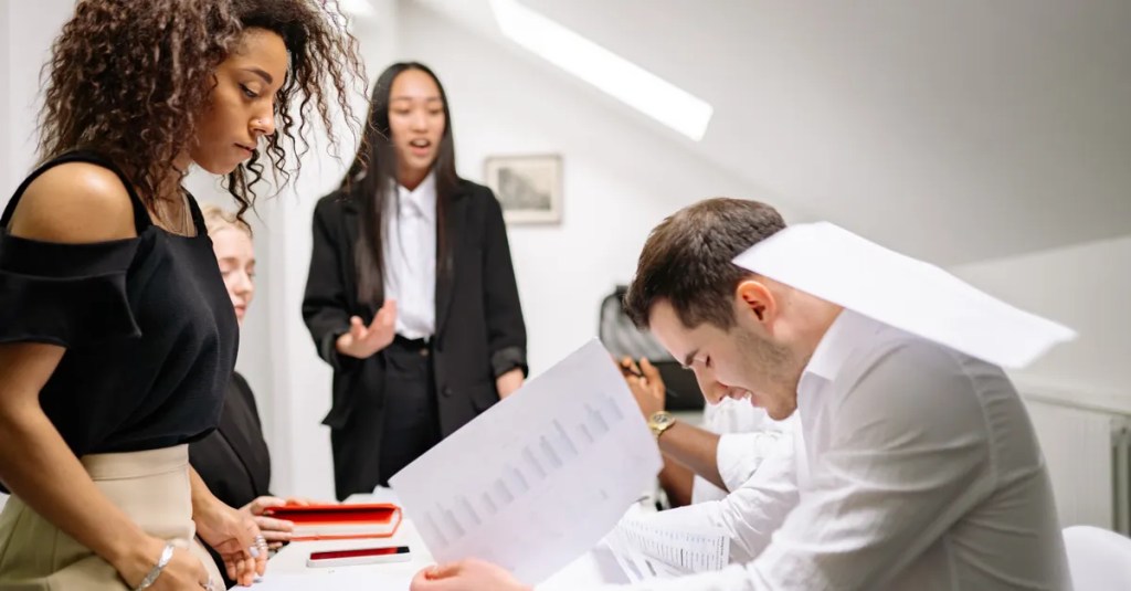 A diverse group of business professionals engaged in discussion and teamwork in a contemporary office.